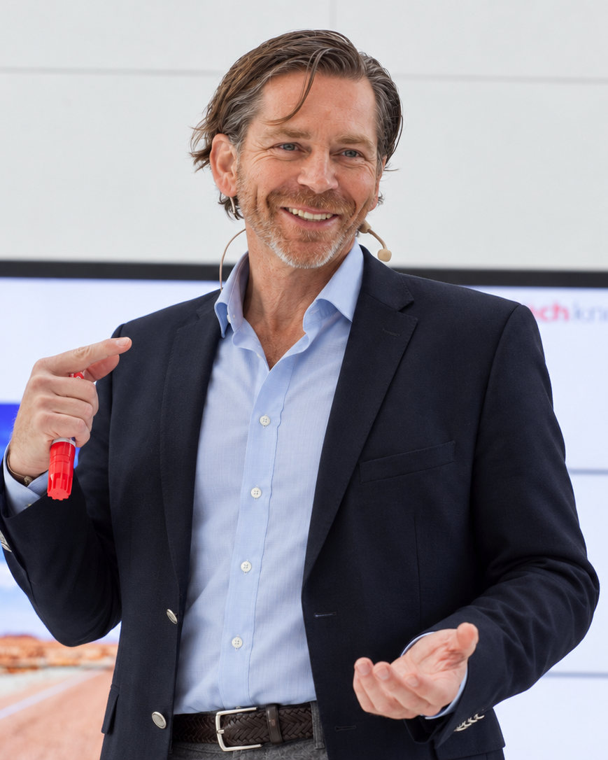 Michael Huger lacht bei einem Vortrag über Verkaufspsychologie